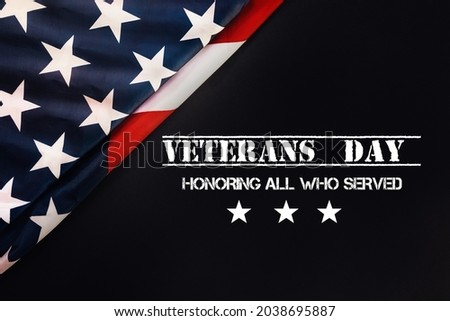 National american holiday banner. Black background with an American flag. Flat lay. The concept of the Veterans Day and patriotism.