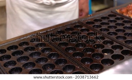 Amazing cooking process Japanese food takoyaki mold close up view taken in Kyoto, Japan store in best angle picture or free copyright photo