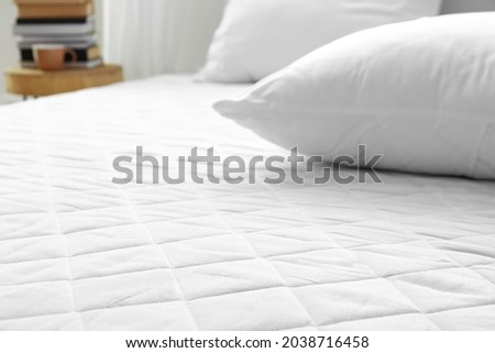 Soft orthopedic mattress on bed in room, closeup Royalty-Free Stock Photo #2038716458