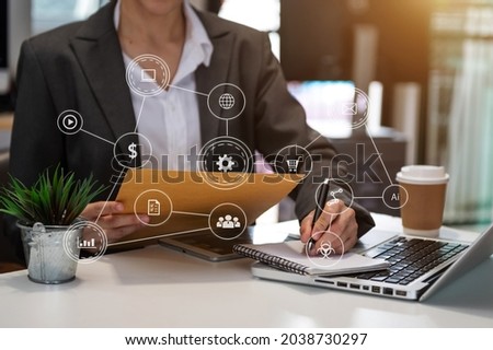 Hands of woman using mobile phone in modern office with laptop and digital tablet computer with VR icon diagram at office in morning light