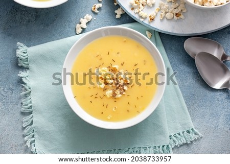 Bowl with tasty popcorn soup on table
