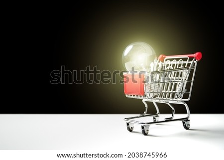 Illuminated vintage lightbulb in the shopping cart close up with copyspace, lightbulb with network and lighting effect.