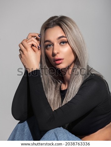 Portrait of beautiful young woman with blonde hair. Girl with long healthy and shiny smooth hair. Ash blond model. Healthy clean skin. Blue eyes and full lips. Royalty-Free Stock Photo #2038763336