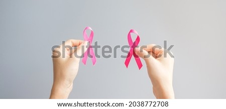 October Breast Cancer Awareness month, hand holding Pink Ribbon for supporting people living and illness. International Women, Mother and World cancer day concept