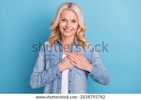 Photo of aged woman happy positive smile hands on heart appreciate grateful love isolated over blue color background