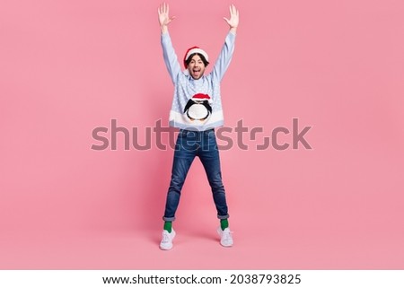 Photo of handsome excited gentleman wear new year sweater smiling rising arms dancing isolated pink color background