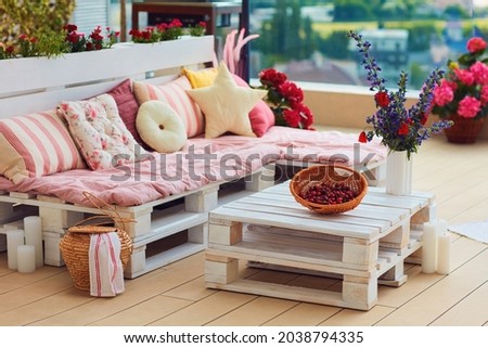 cute, cozy pallet furniture with colorful pillows at summer patio, lounge outdoor space Royalty-Free Stock Photo #2038794335