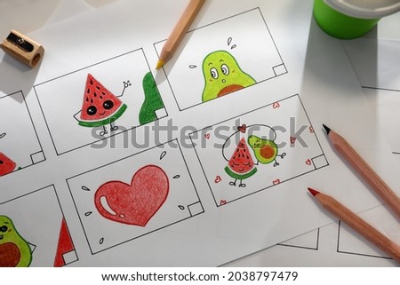 Storyboard with cartoon sketches at workplace, flat lay. Pre-production process Royalty-Free Stock Photo #2038797479