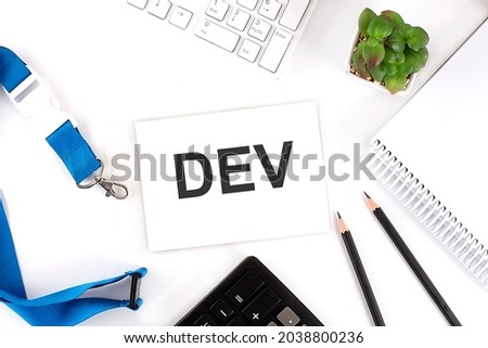 DEV Words on card with keyboard and office tools Royalty-Free Stock Photo #2038800236