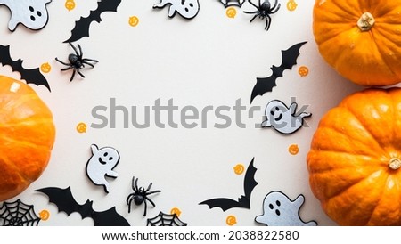 Cute halloween flat lay composition with pumpkins, ghosts, bats, spiders, web on white background. Flat lay, top view, copy space. Happy Halloween banner design. 
