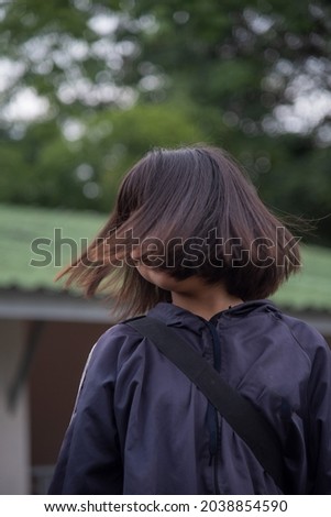 Picture taken on September 9, 2021, around 8.30 am, Mae Hong Son Province, Thailand. A woman wearing a blue jacket is brushing her black hair.