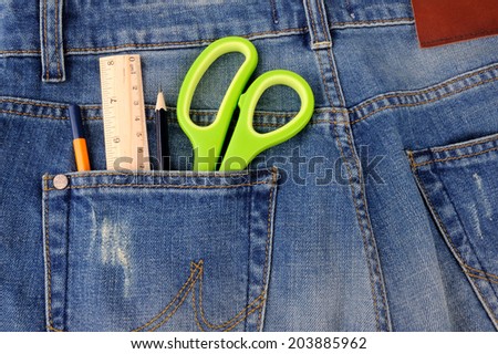 Scissors ruler and pencil in  the blue jeans back pocket 