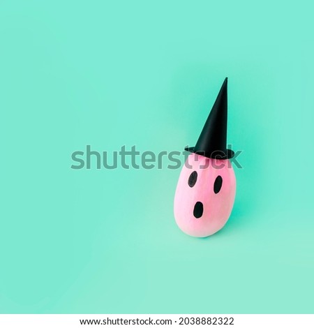 Pink pumpkins as a ghost for Halloween. Background of the concept of the minimum holiday season in pastel mint color.
