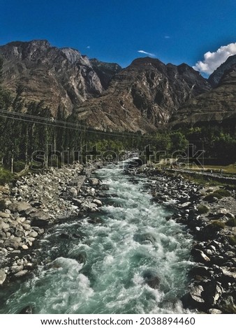 This is picture of gilgit in Pakistan. It has mountains,trees,river in it.