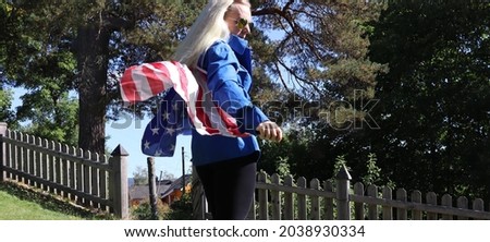 Free energetic and wild caucasian woman protester with blond hair blue jacket black pants and wings that symbolises the american flag accessory concept outdoors celebrations holidays and changes 