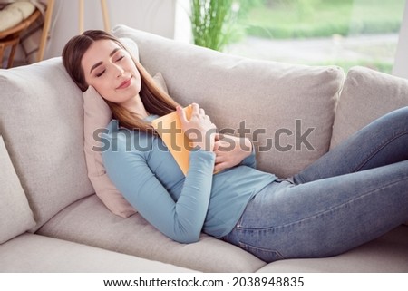 Photo portrait young woman sleeping on couch keeping book relaxing at home