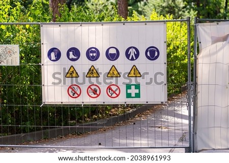 Information panel with forbidden and permissible signs at the construction site metal fence