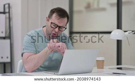 Young Man having Wrist Pain while working on Laptop