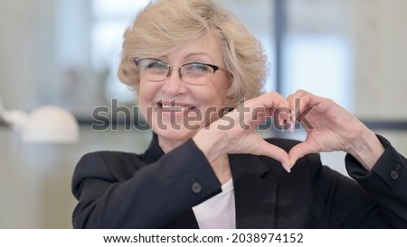 Old Businesswoman showing Heart Sign by Hand 