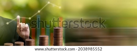 Businessman touching point growing business graph on saving money coin stack background. Business panoramic banner