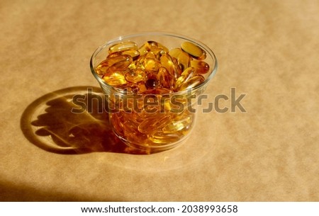 Capsules in a transparent glass bowl on craft background. Healthy lifestyle concept