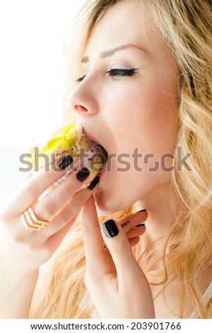closeup portrait picture of eating alone large fruit creamy cake beautiful blond young lady cute green eyes girl having fun enjoying eyes closed on light copy space background 