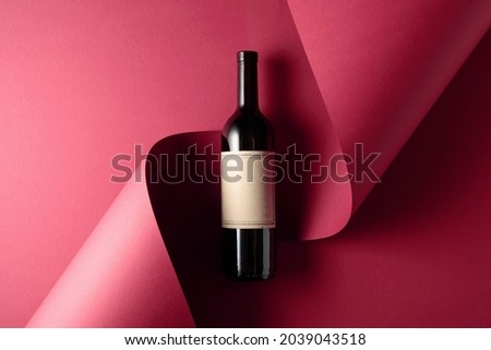 Bottle of red wine with old empty label and blue grapes. Copy space for your text, top view.