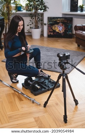 Beautiful sportive woman prepares her equipment in studio room