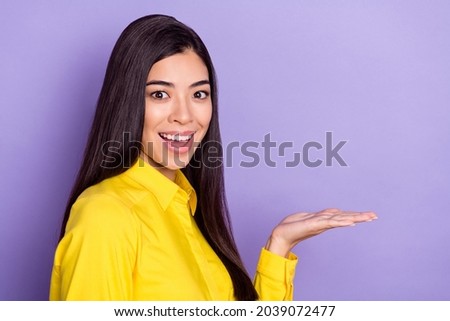 Photo of agent brown hairdo young excited lady hold empty space wear yellow shirt isolated on purple background
