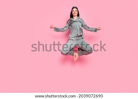 Photo of pretty sweet young woman nightwear smiling jumping high enjoying yoga isolated pastel pink color background