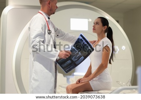 Male doctor explaining to female patient result of MRI examination in clinic