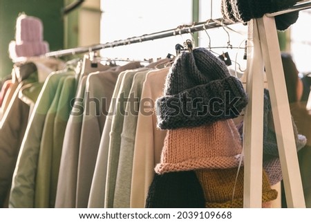 Clothes on the rail on the autumn fashion designer market. Garage sale, reuse the clothes, second hand and eco consumering Royalty-Free Stock Photo #2039109668
