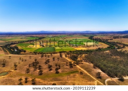 Hunter river in a loop shape around cultivated agriculture fields and farms in a wide valley of hunter region - aerial scenic landscape, Australia. Royalty-Free Stock Photo #2039112239