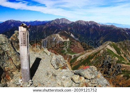 view of Mountains in the northern part of the Southern Alps　from the summit of mt.shiomi,ina city,nagano prefecture,japan.
I translate the  japanese written on the sign: Mt.shiomi,east peak 3052m Royalty-Free Stock Photo #2039121752