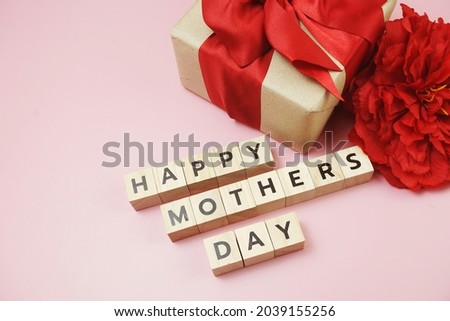 Happy Mothers day alphabet letter with gift box and red flower decoration on pink background