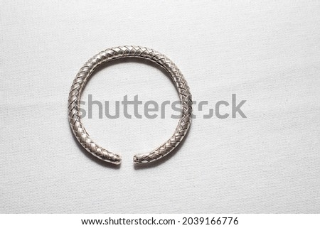 Antique braided real silver bangle on white cloth background