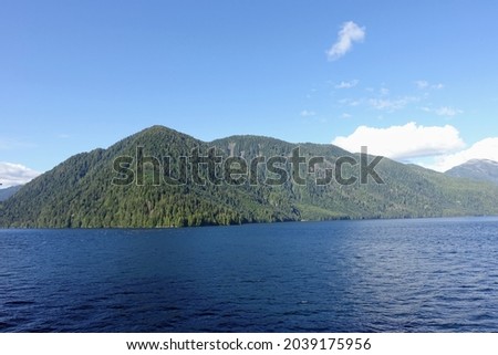 Majestic views of the forested mountains and beautiful blue ocean along the british columbia coast along the BC ferries inside passage route, on a beautiful sunny day