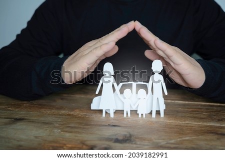 Insurance house, and family health live concept. The insurance agent presents the hands protection model that symbolize the coverage.