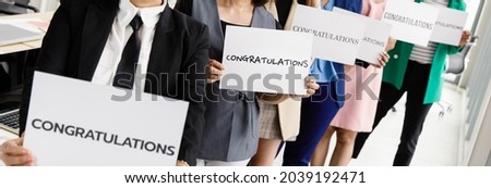 Businesspeople group in business clothes set row and holding paper banner with word congratulations and show to camera. Concept of greeting and appreciation for success in job or work in company.