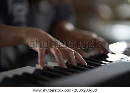 The musician's hands on the synthesizer. A cropped image of a person playing a synthesizer. Side view. High quality photo