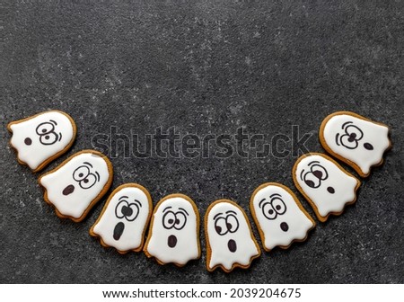 gingerbread halloween white ghosts on dark stone background copy space