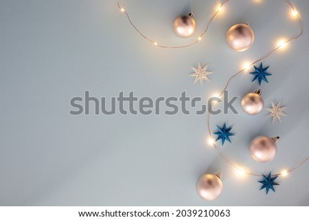 Christmas Decorative Background with Decor, Balls, Christmas Lights, Stars. Top view Flat lay with copy space on the Left side. With Gold, Silver, White, Blue, Yellow Tones