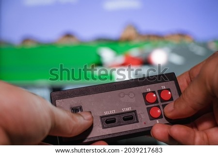 In the background of the image with the game of hands with the old joystick. The concept of home entertainment