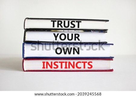 Trust your own instincts symbol. Books with words 'Trust your own instincts'. Beautiful white background. Businessman hand. Copy space. Business and trust your own instincts concept. Royalty-Free Stock Photo #2039245568
