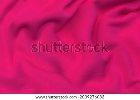 Close-up texture of natural red or pink fabric or cloth in same color. Fabric texture of natural cotton, silk or wool, or linen textile material. Red and orange canvas background.
 Royalty-Free Stock Photo #2039276033