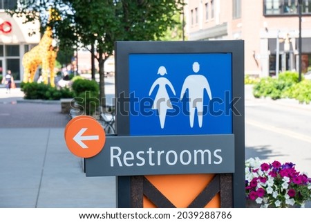 Public Restrooms wooden sign with arrow to the left in Boston, USA.