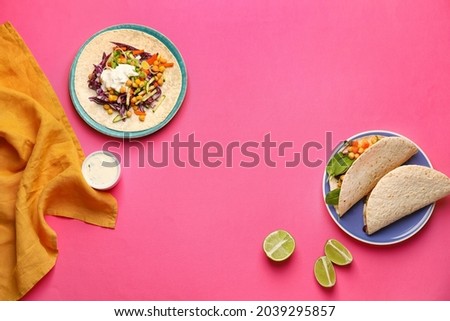 Plates with tasty vegetarian tacos on color background