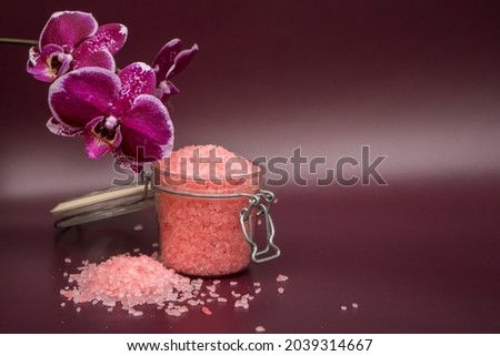 Pink bath salt with orchid flower on vinous background . High quality photo