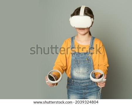 Child girl playing virtual reality over grey background, digital technology concept, innovative technologies