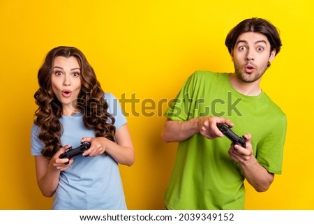 Photo portrait couple having date playing video games crazy amazed isolated vivid yellow color background